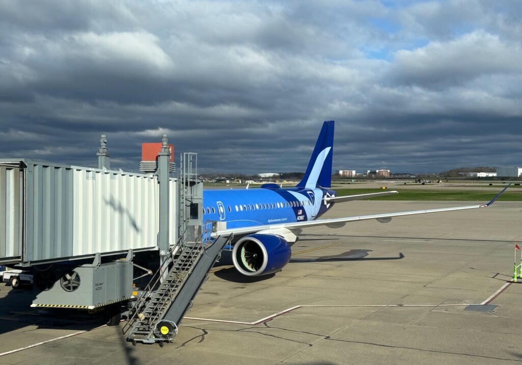 a blue and white airplane on a tarmac