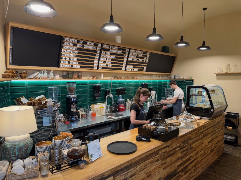 a woman standing at a counter in a coffee shop