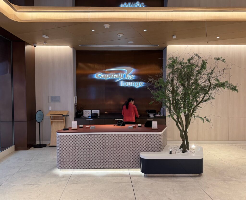 a woman standing at a desk in a lobby
