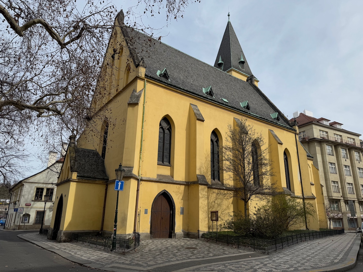 a yellow building with a tree in front of it