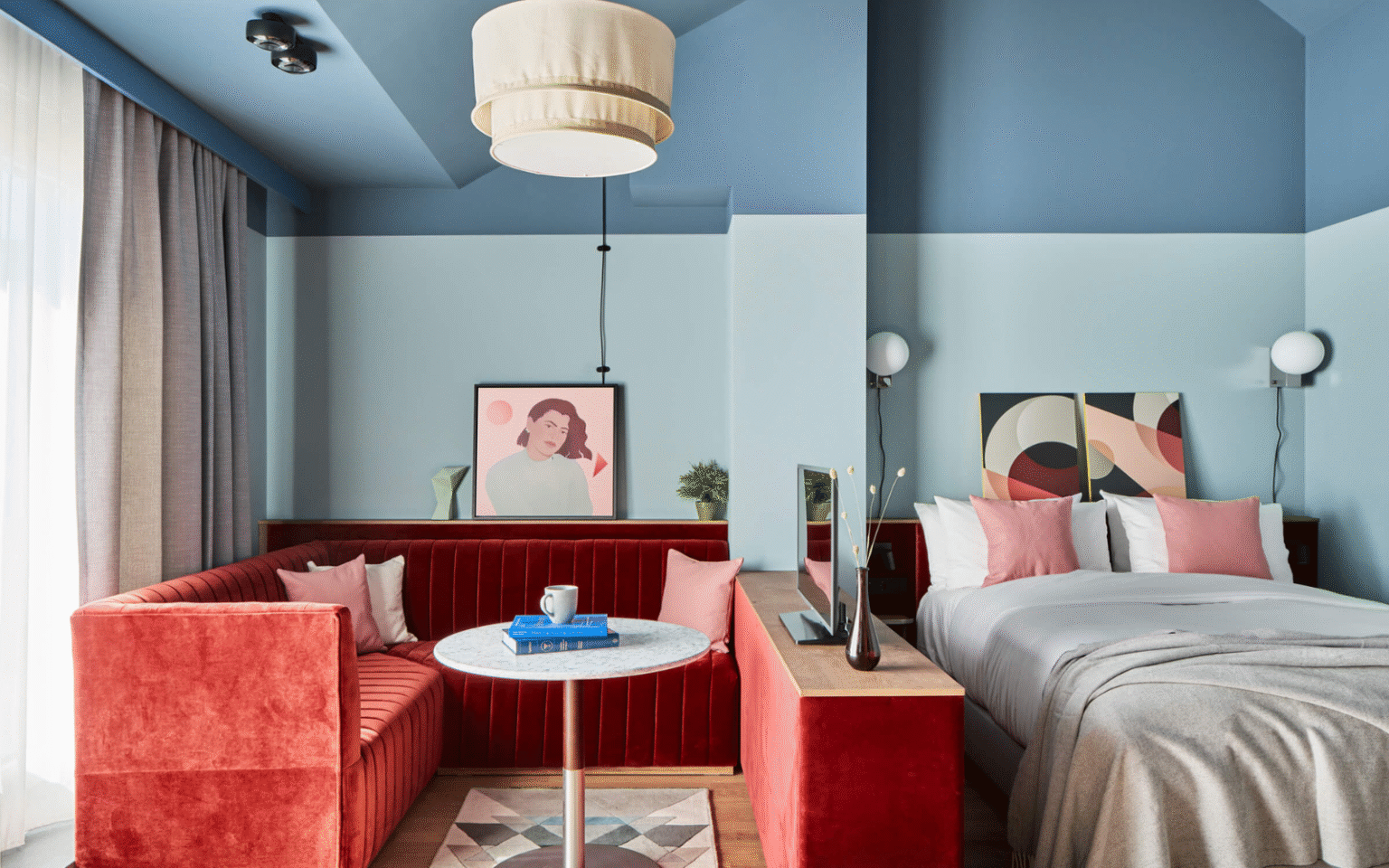 Pale blue walled room at Locke Munich with rust coloured seating area