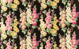 Hollyhocks fabric by Sanderson with black background and repeating pattern of a yellow, pink and cream hollyhock