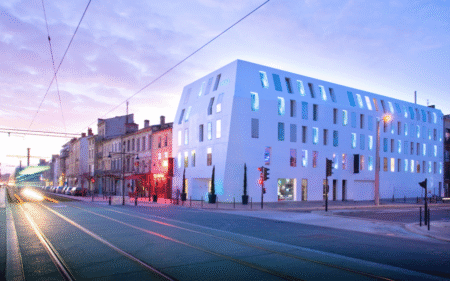 Shot of Seeko'o Hotel in Bordeaux during sunset. Building facade is Corian cladding creating a smooth white outer