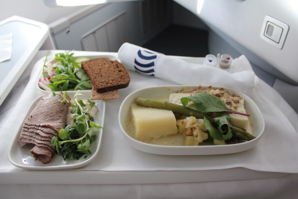 Amuse bouche served in crystal dish with lettuce, cream, and garnishes on Finnair Business Class flight from Helsinki to Beijing.