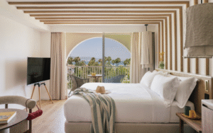 double bed in hotel guestroom ME Marbella with arched window and sea view