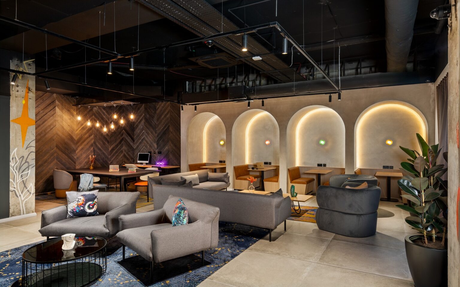 Moxy Belfast City – a milestone 100th Moxy opening seating and tables in front of backlit arches in Moxy Belfast City - Lounge