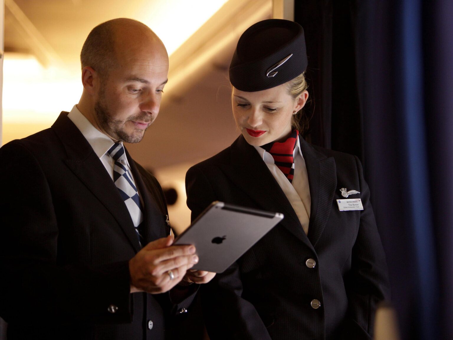 a man and woman in uniform looking at a tablet
