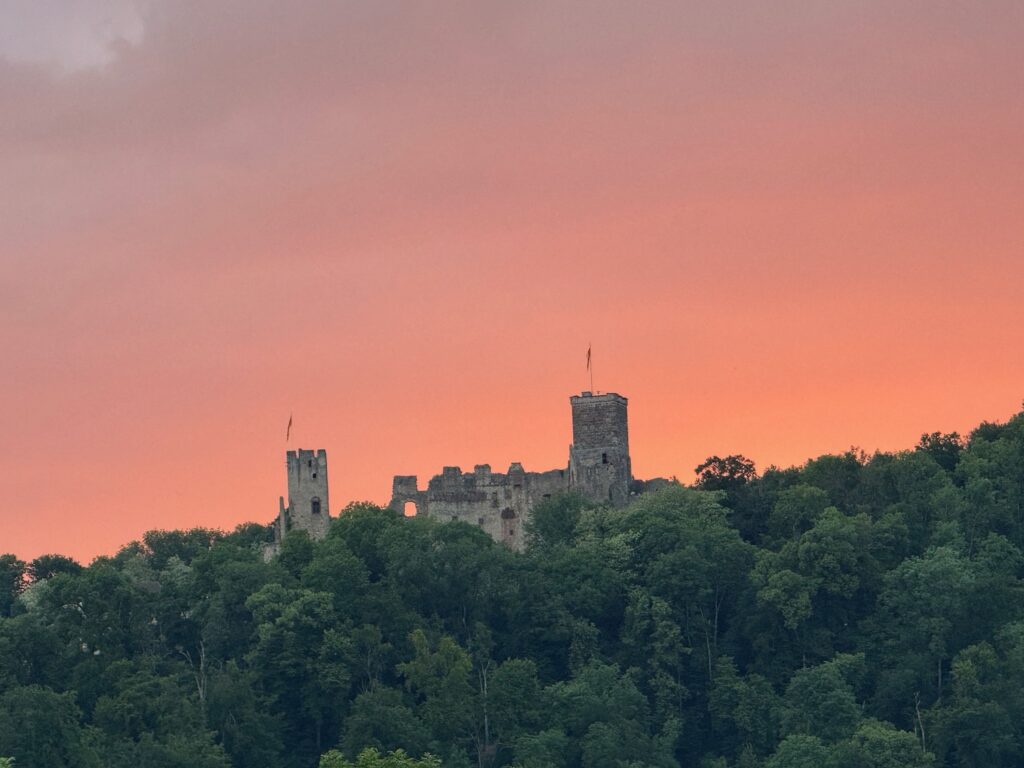 a castle on top of a hill with trees in the background