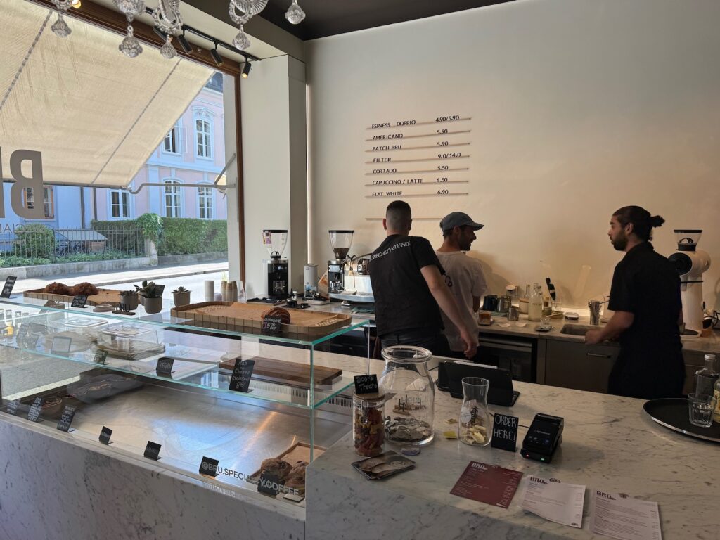 a group of men standing behind a counter in a coffee shop