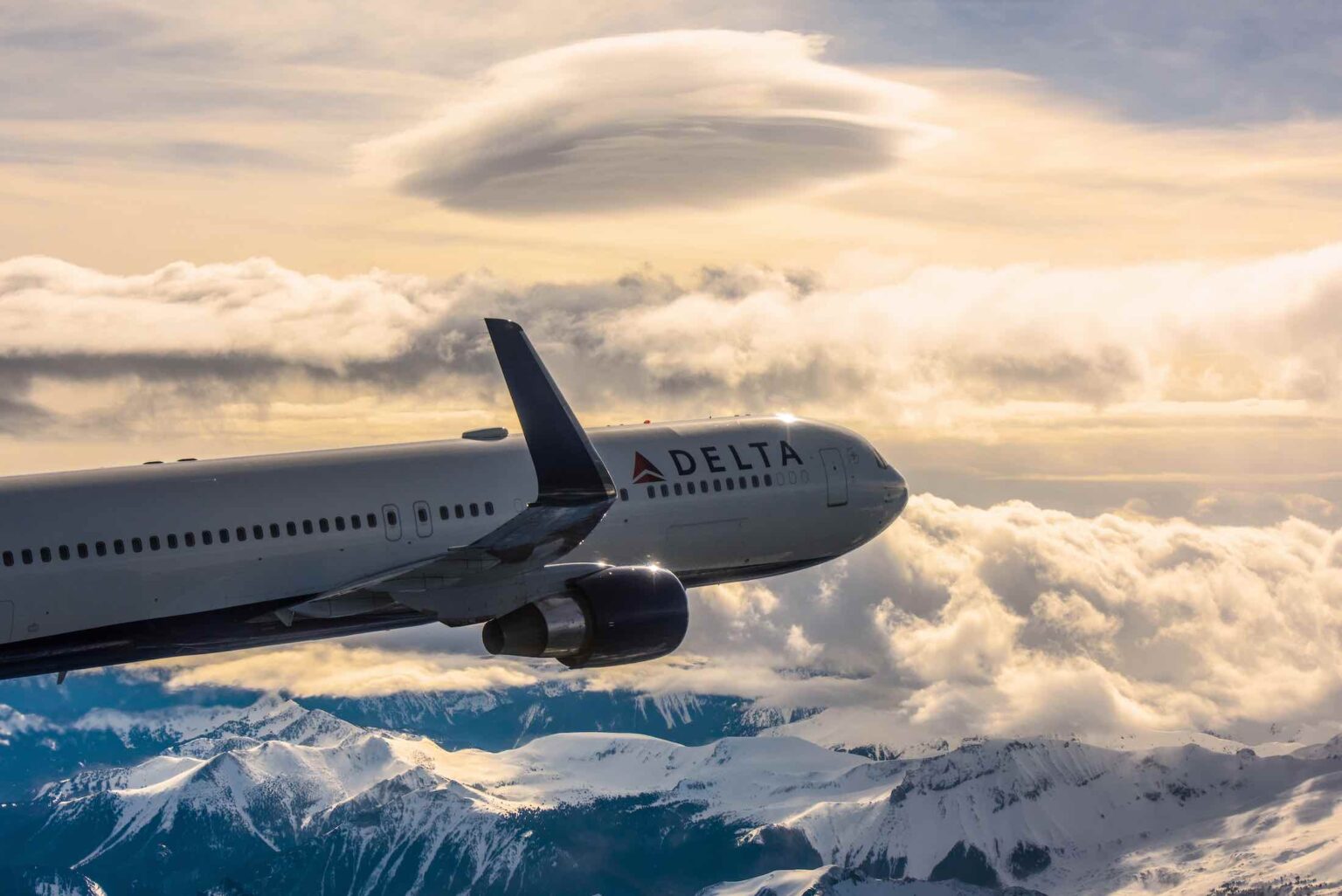 a plane flying over snowy mountains