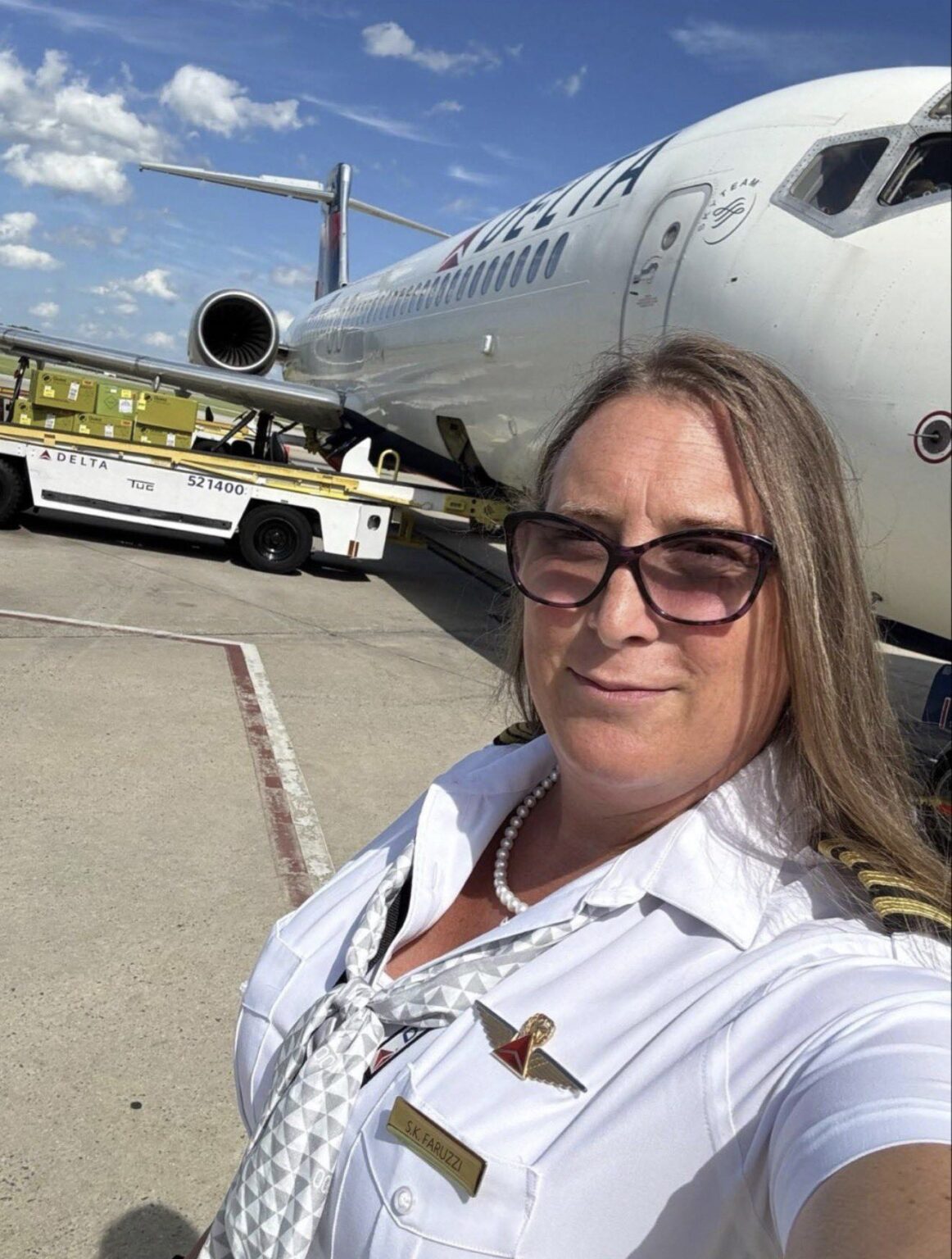 a woman taking a selfie in front of an airplane