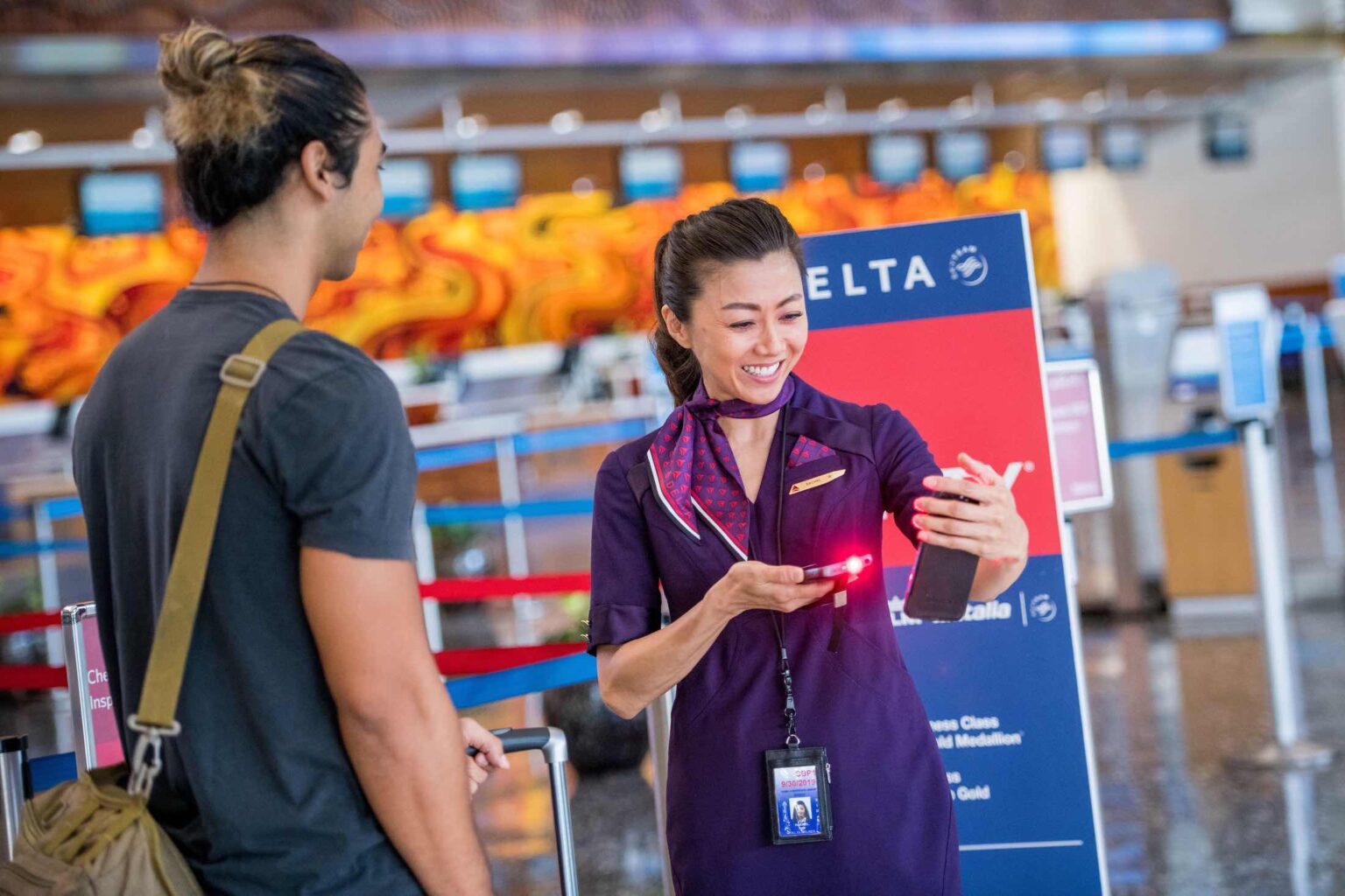 a woman holding a device with a man in the background