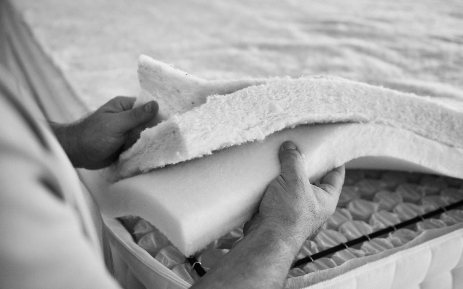 Inside the Silentnight factory: where mattresses are stitched and shredded black and white image of layers of mattress fabric being held together by an individual at the Silentnight factory
