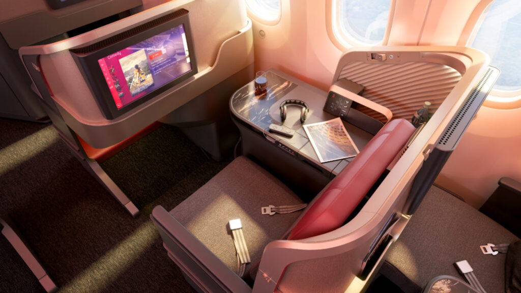 a table with headphones and a tv in the back of a plane