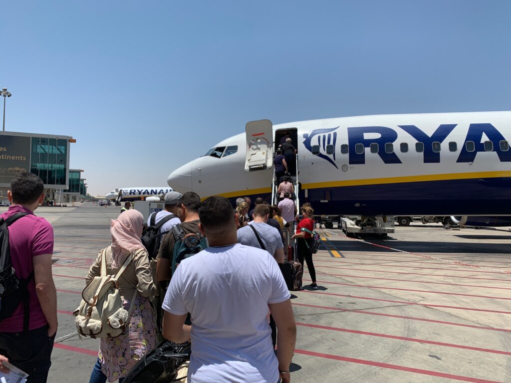 people boarding an airplane at an airport