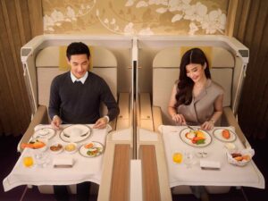 a man and woman sitting at a table with food