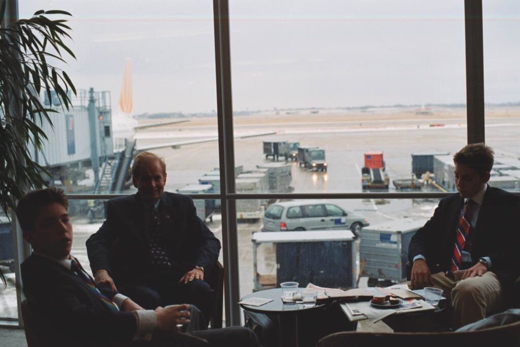 a group of men sitting in a room with a window