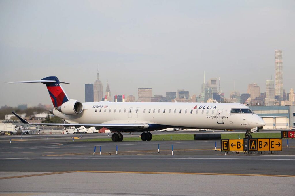 “Act Your Wage!” Delta Regional Flight Attendants Told They Don’t Get Paid To Argue With Passengers a plane on the runway
