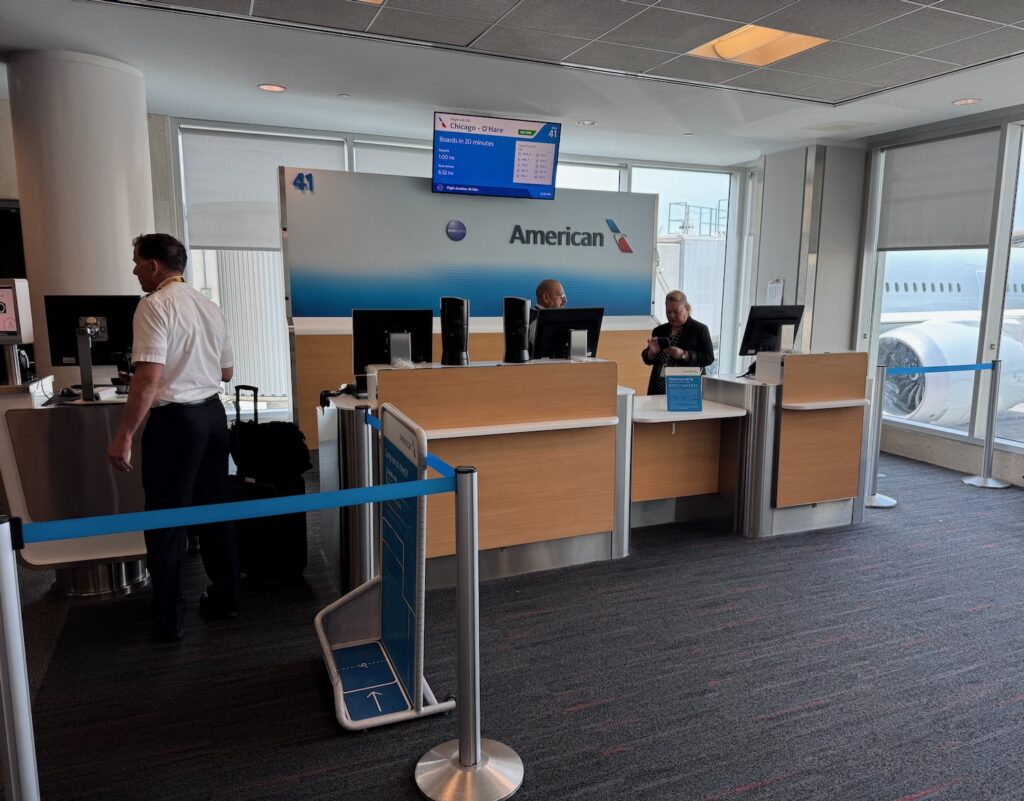 Why Is American Airlines Removing Baggage Sizers At Gates? people standing in front of a computer