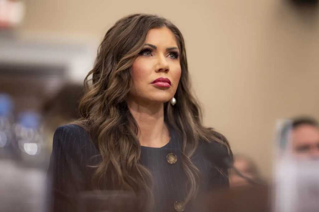 DHS Spends $172M On Luxury Gulfstream Jets For Kristi Noem, Citing “Safety” Concerns a woman with long hair wearing a blue dress