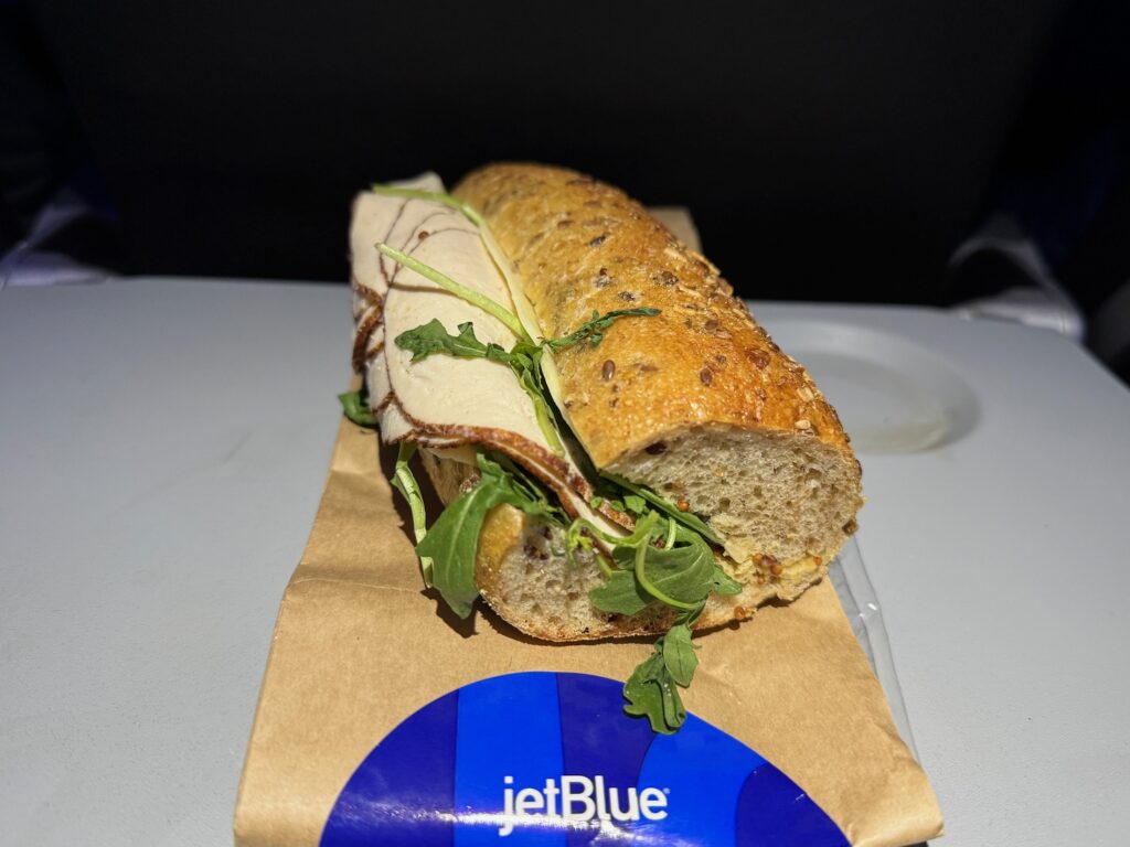 My Hearty Turkey Havarti Sandwich On JetBlue a sandwich on a paper wrapper