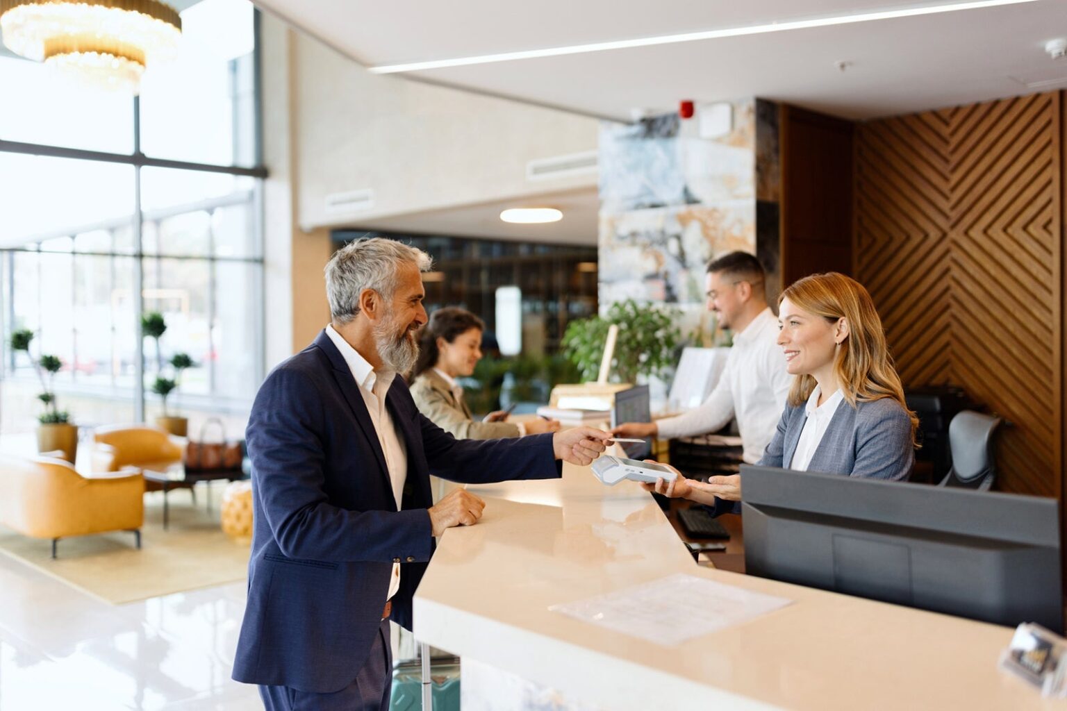 Earning rewards on your business spending? Here's how to redeem for the best value Man paying something with a credit card at the hotel reception