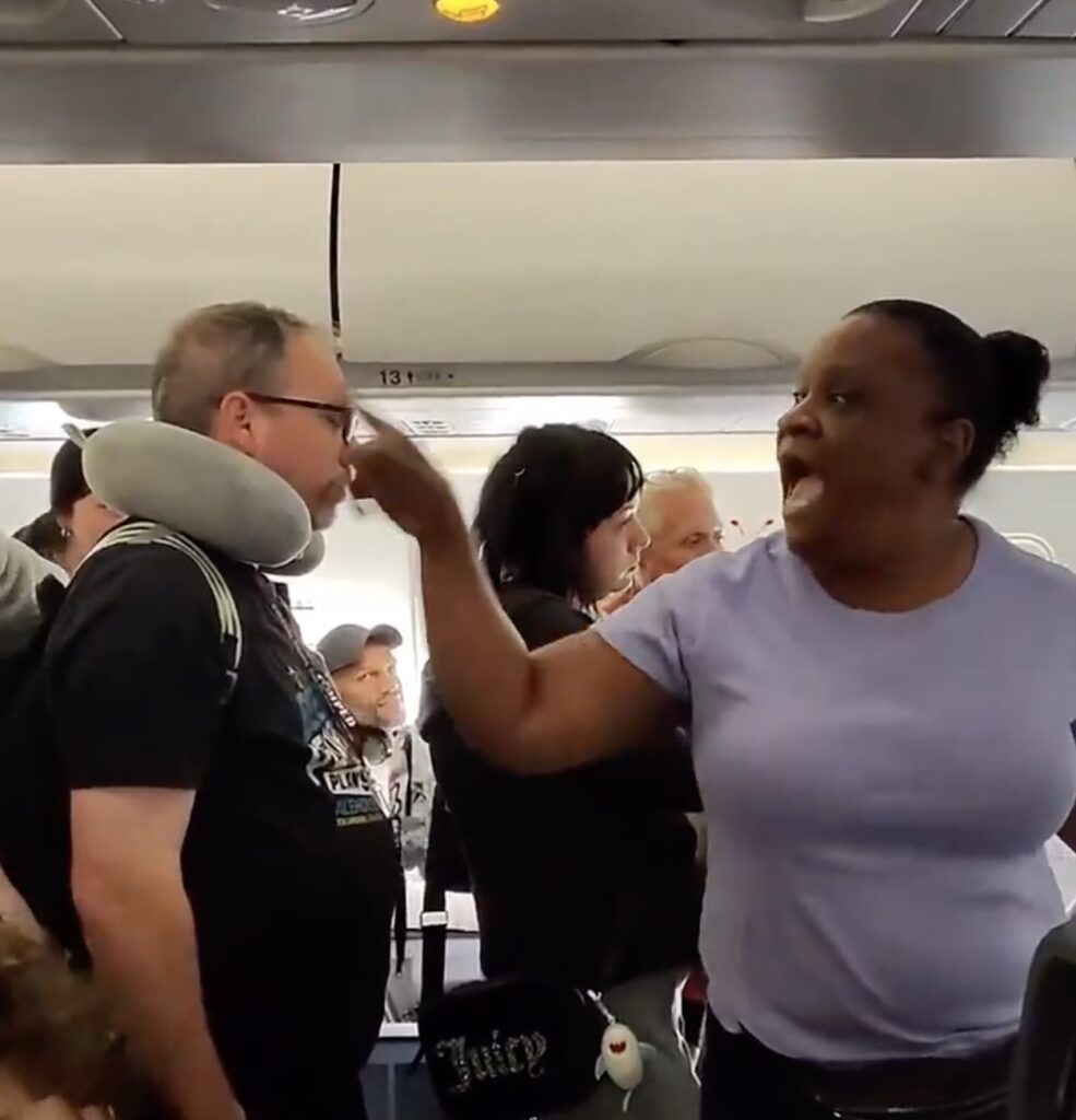 “Nobody’s Leaving!” Mom Blocks Frontier Airlines Aisle After Landing, Demands Child Deplane First a woman standing in a crowd of people