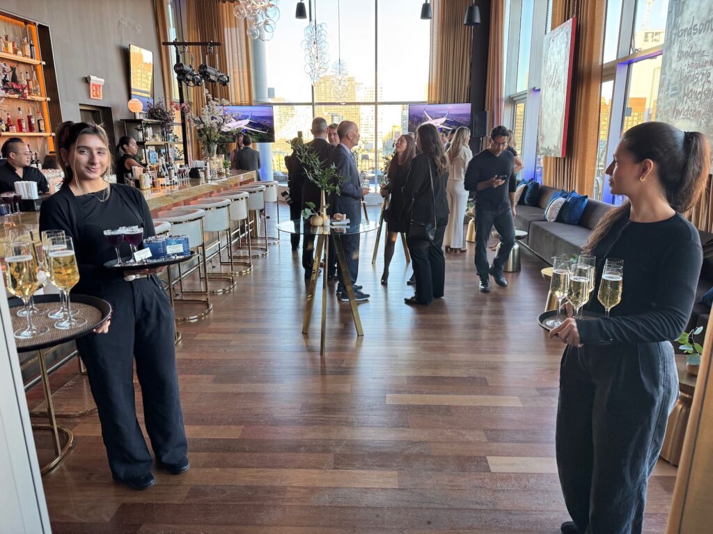 I Flew To New York For A Two-Hour Reception…Then Flew Right Back a group of people in a room with tables and chairs