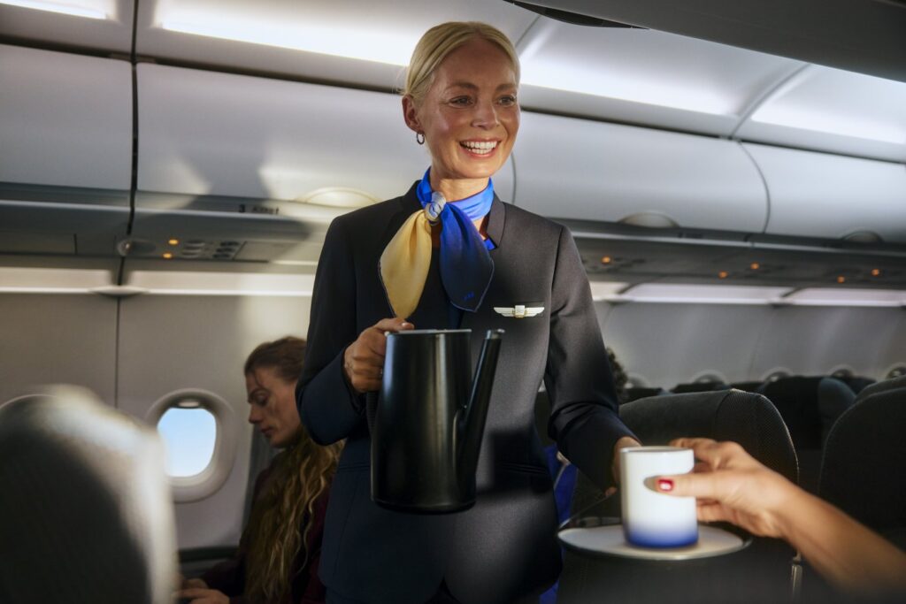 SAS Restores European Business Class Flight attendant serving coffee in Scandinavian Airlines (SAS) European business class cabin, featuring a modern interior and attentive service.