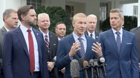 a group of men in suits standing in front of microphones
