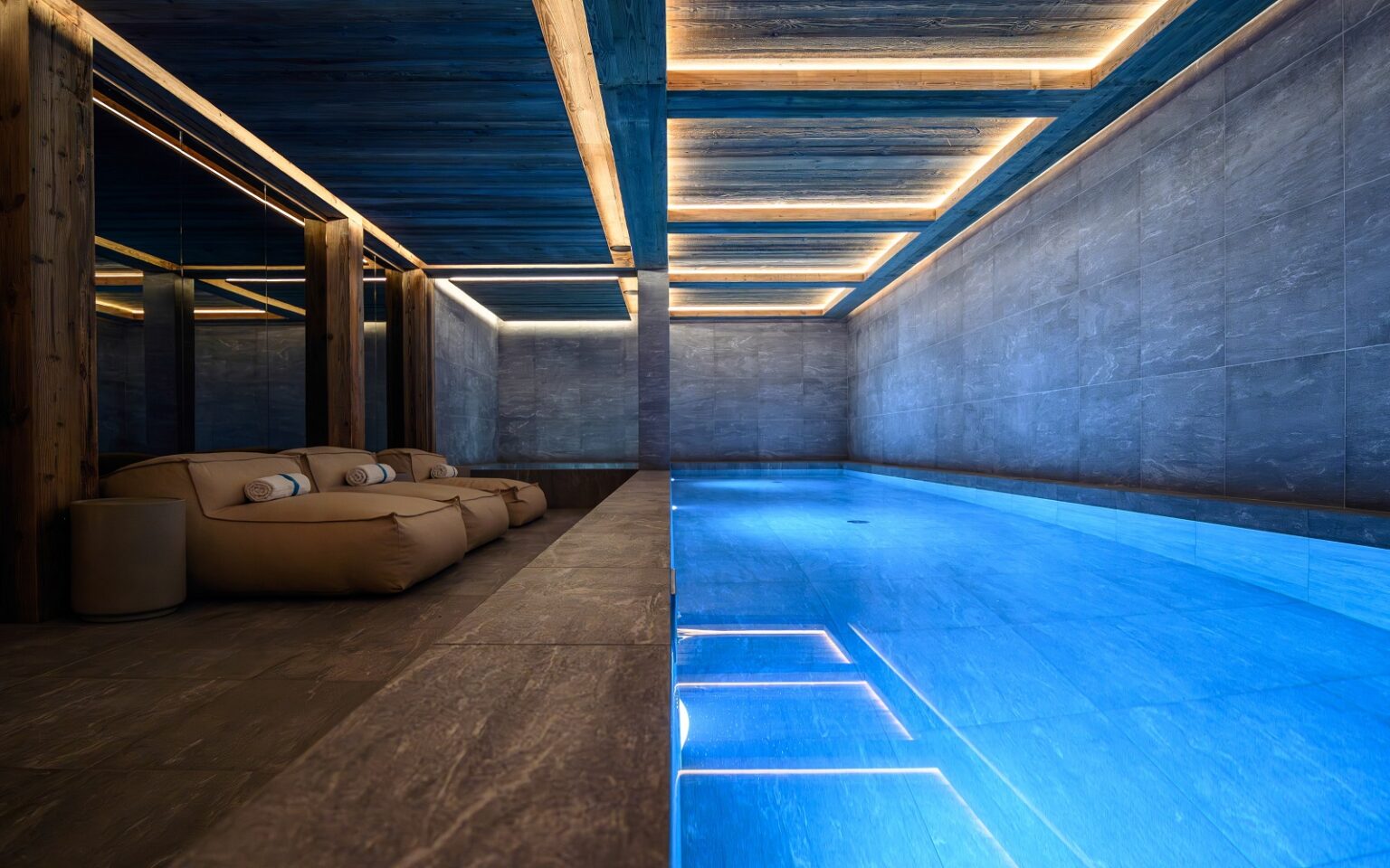 Chalet Cervinia – a new star in the Purple Ski portfolio indoor spa pool at ski chalet with bright blue water contrasting with raw concrete walls