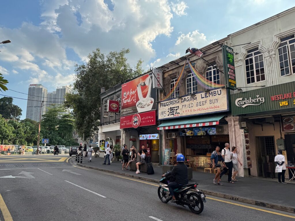 a street with a motorcycle and people walking on it