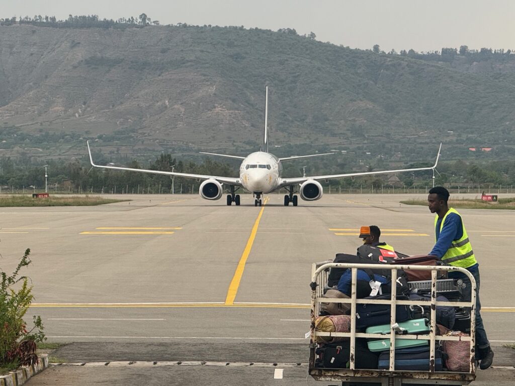 a group of people sitting on a runway with a large white airplane