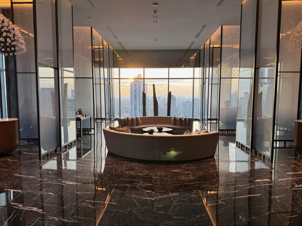 a large round couch in a room with glass walls and a city view