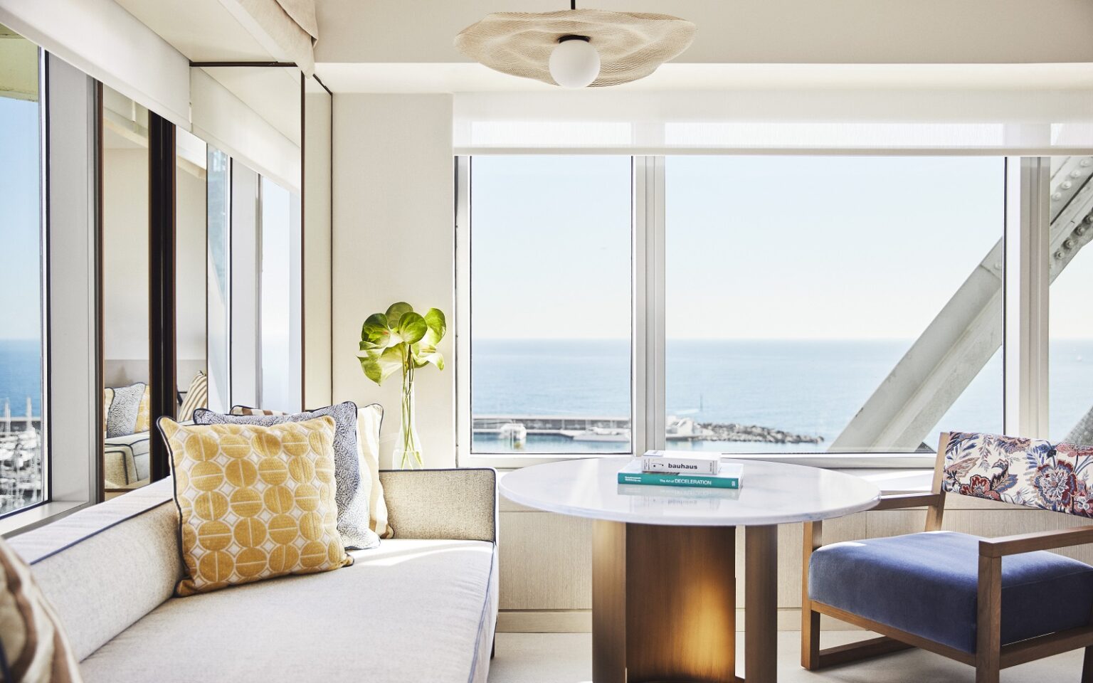 guestroom in Hotel Arts Barcelona with cream couch next to window with sea view