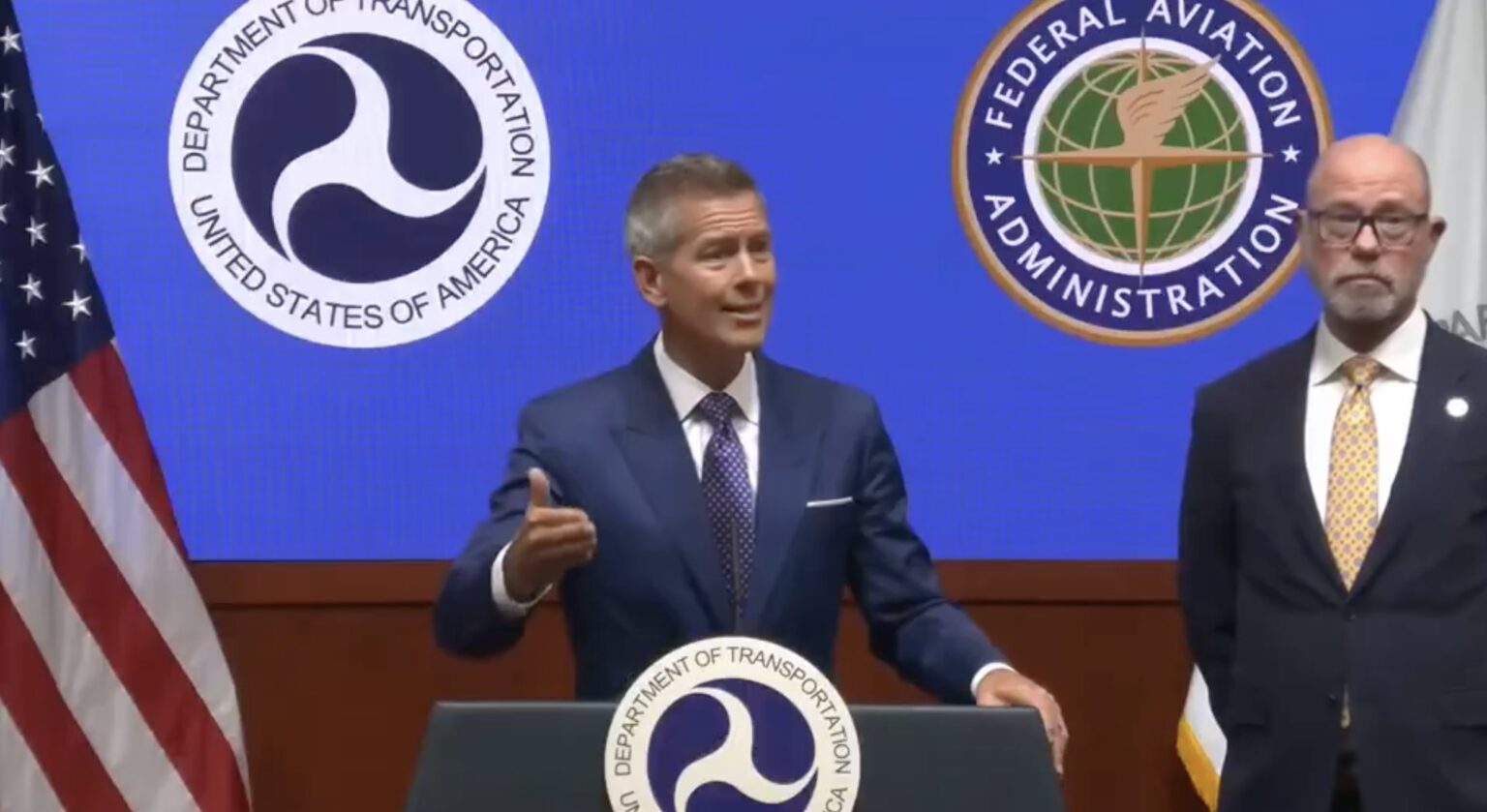 a man standing at a podium giving a thumbs up