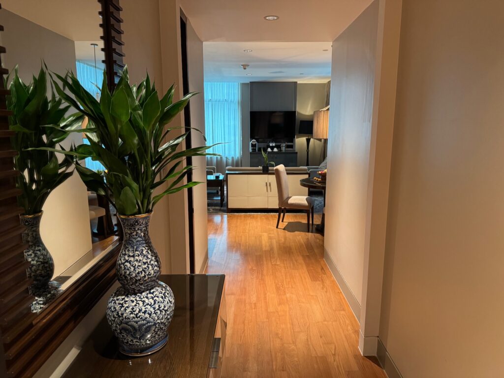 My Suite Stay At St. Regis Bangkok a hallway with a plant in a vase