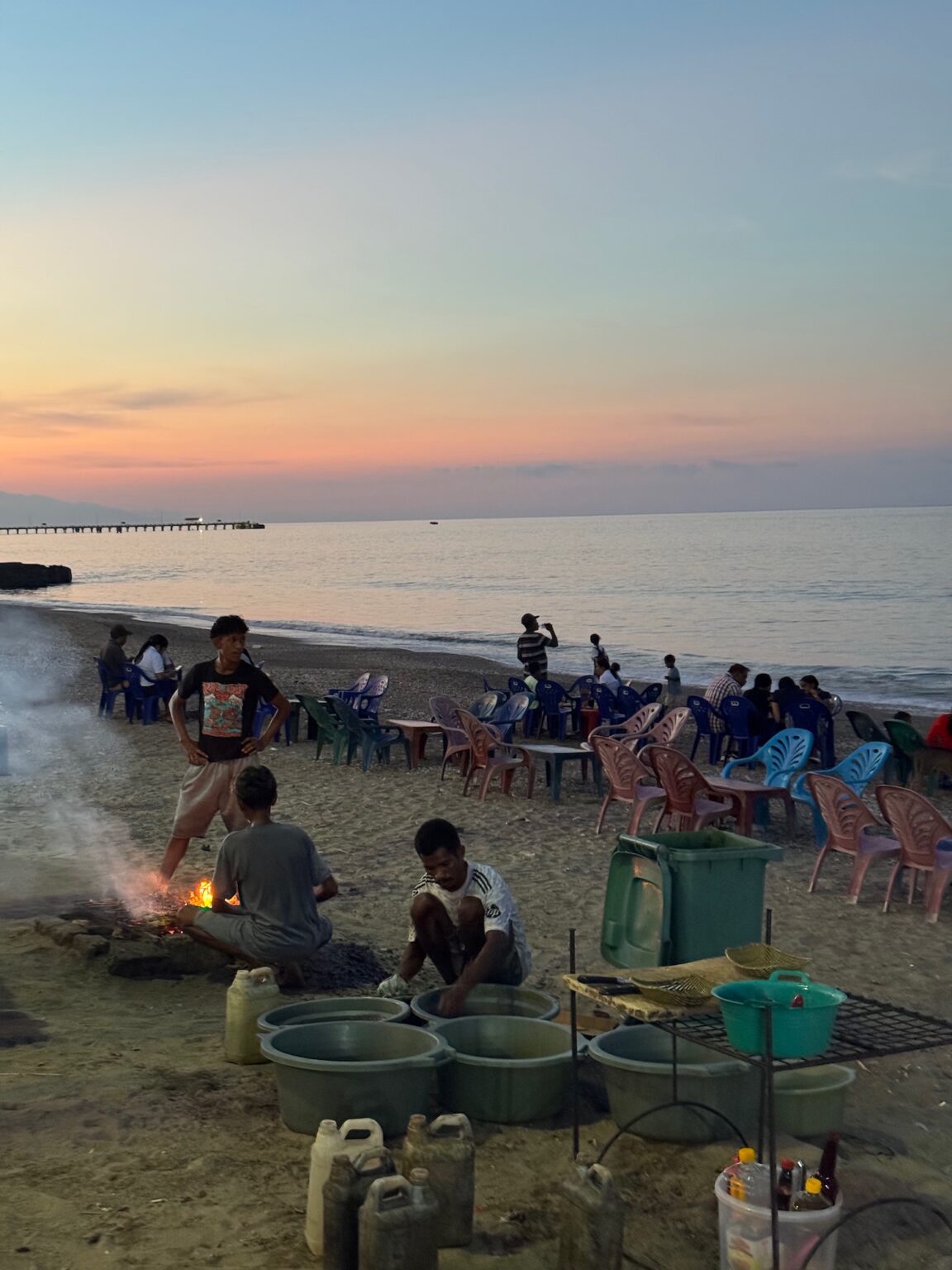 people around a fire on a beach
