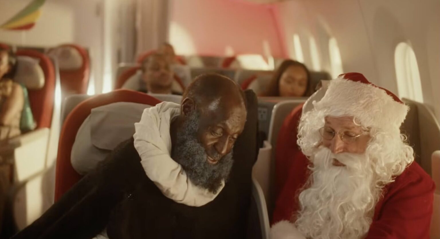 a man in a garment sitting on a chair next to a man in a garment