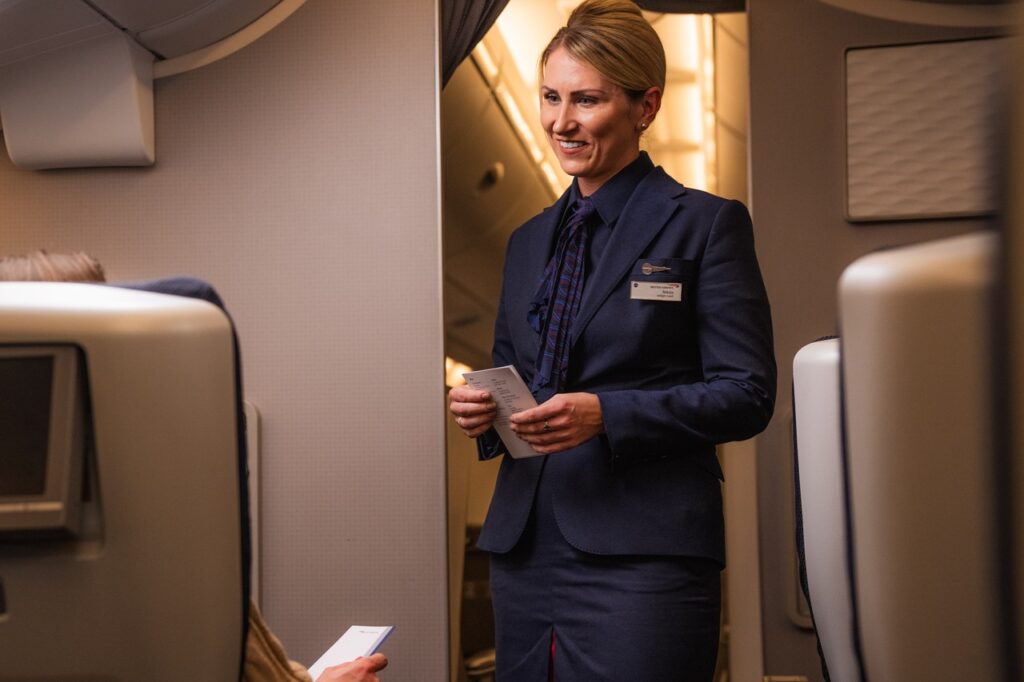 a woman in a suit standing in an airplane