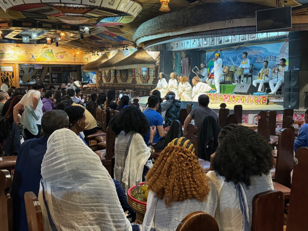 a group of people sitting in chairs in a room with a stage