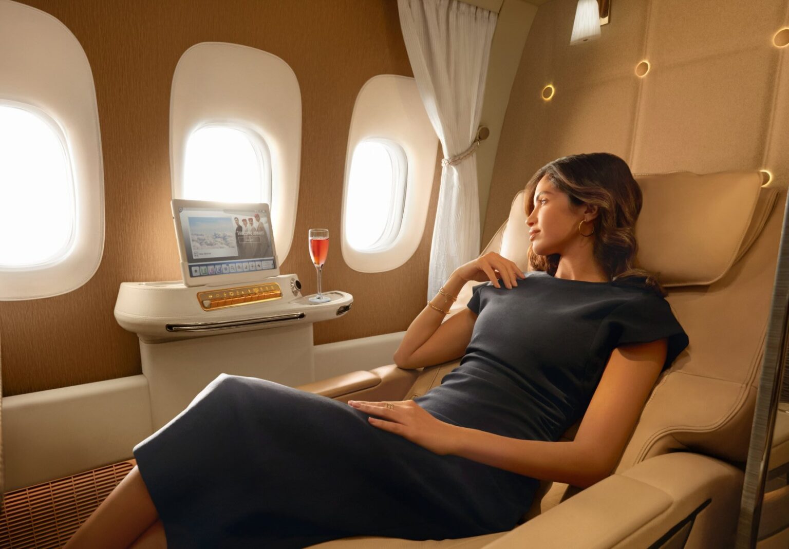 a woman in a black dress sitting in a chair in a plane