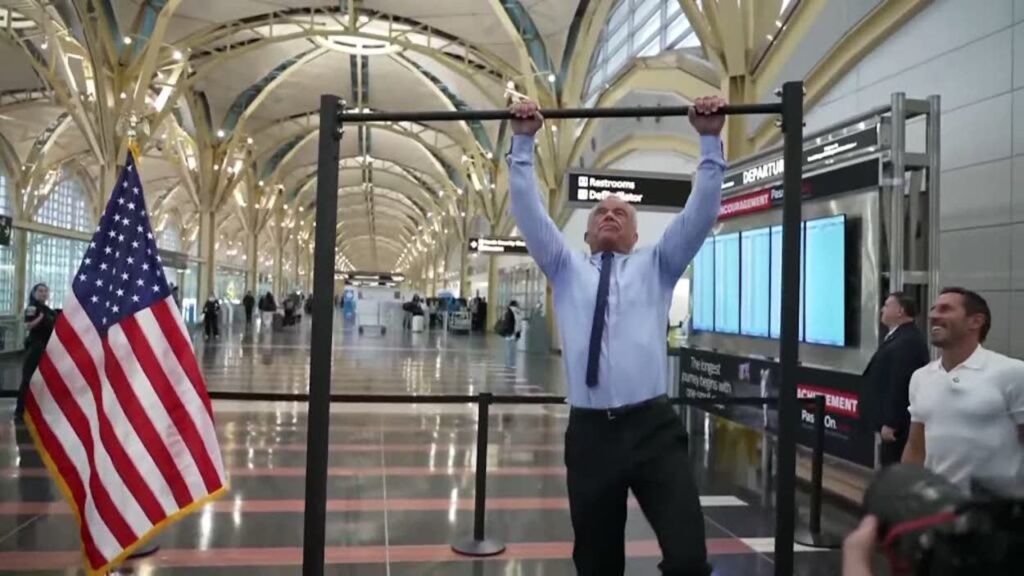 a man holding up a bar in a building