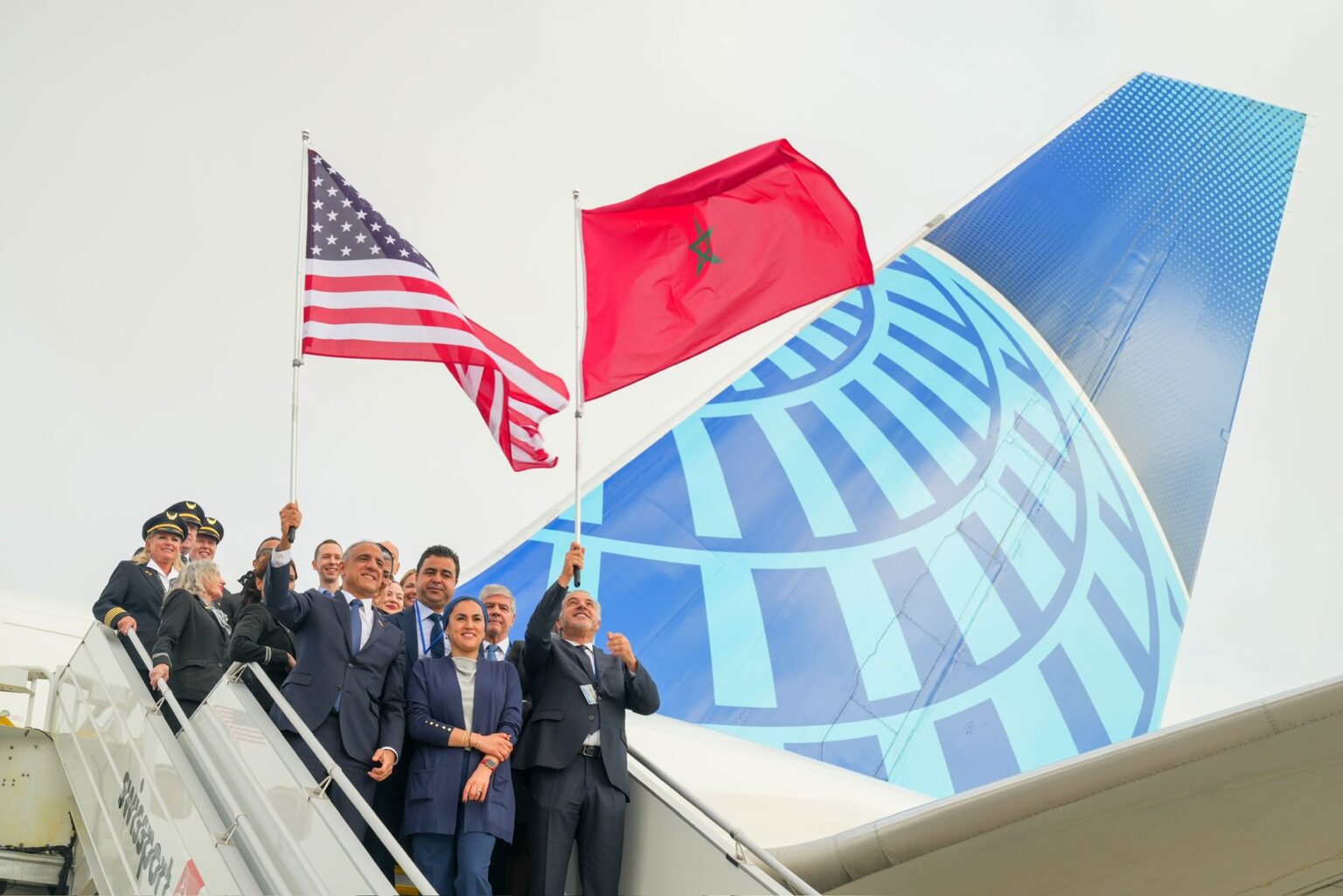 a group of people standing on a plane with flags