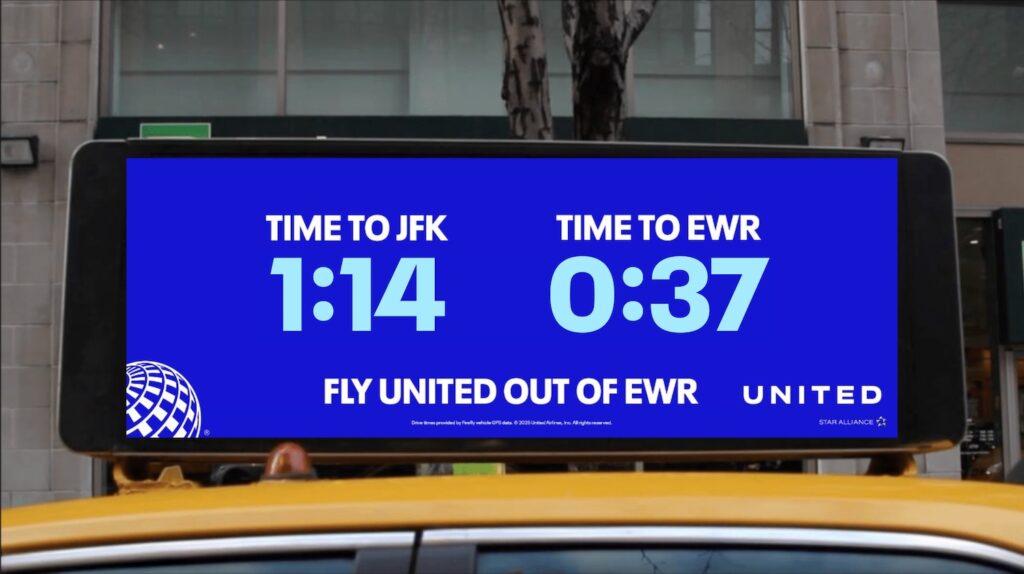 a sign on top of a yellow taxi