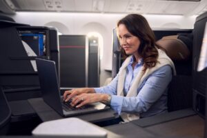 American Airlines Adds Starlink Wi-Fi, But Bypasses The Jets That Need It Most a woman sitting at a desk using a laptop