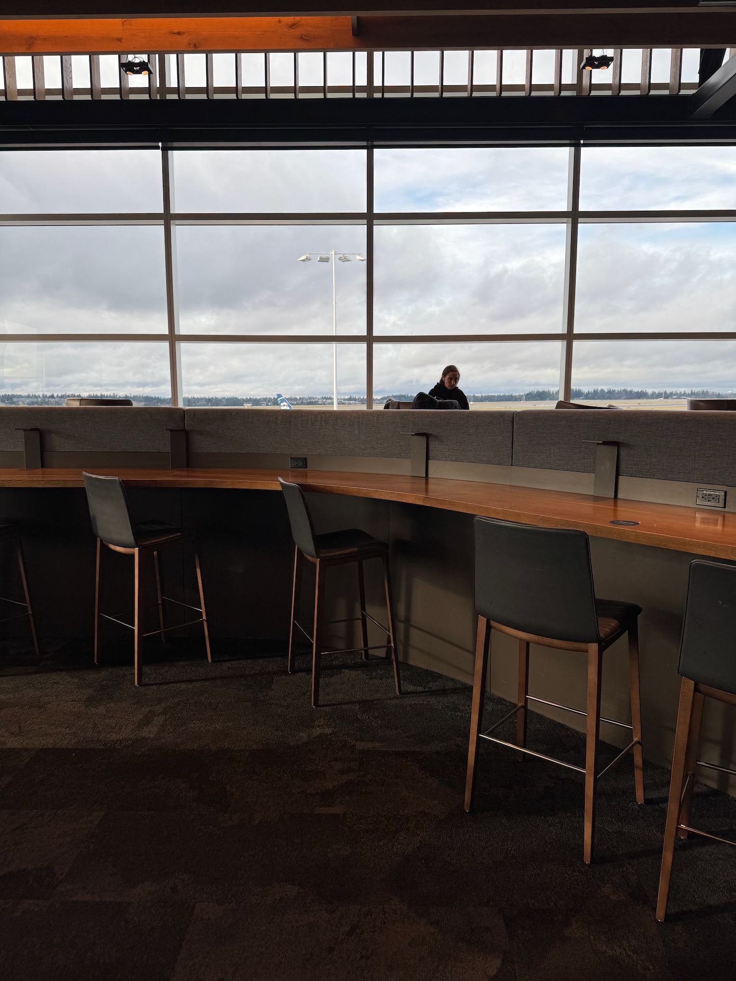 a long table with chairs and a man sitting in the background