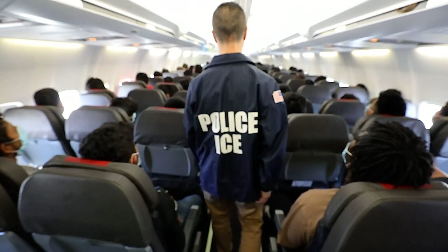 a man in a blue jacket with white text on it