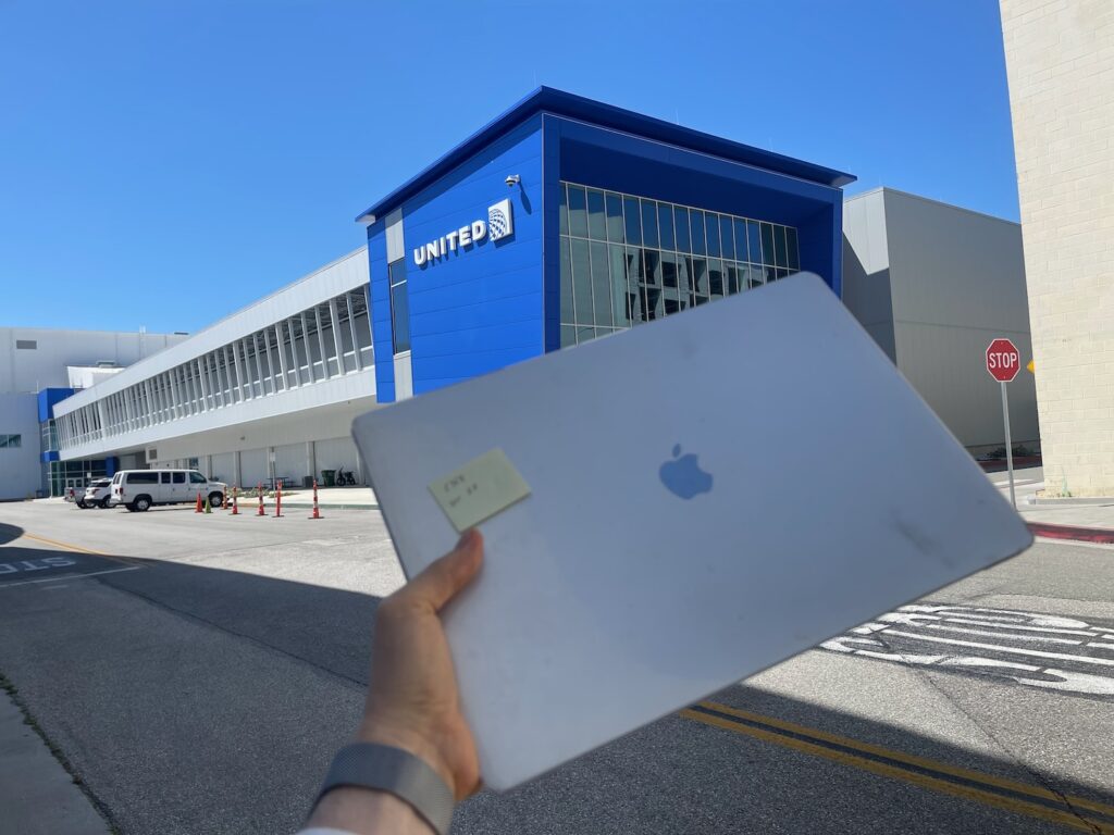 I Left My Laptop On A United Airlines Flight And Tracked It Down Myself a hand holding a tablet in front of a building