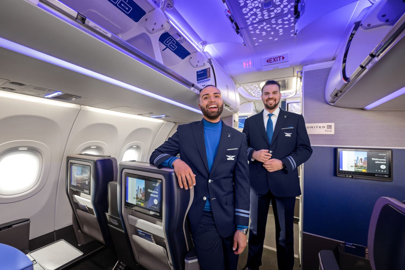 United Airlines Lays Out Contract Tradeoffs For Flight Attendants As Pay Talks Intensify two men in blue uniforms standing in an airplane